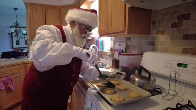 Santa Claus bakes cookies. 