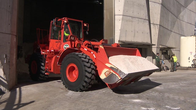 A New York City sanitation vehicle with a scoop full of road salt. 