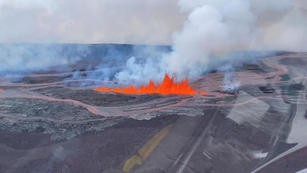 An aerial view from a helicopter cockpit shows lava spewing out of the earth during Mauna Loa's eruption in Hawaii, November 28, 2022, in this still image taken from social media video. 