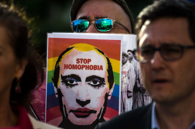 A man showing a picture of Vladimir Putting during a protest 
