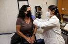 A nurse practitioner prepares to administer a flu shot to a woman in a Florida clinic 