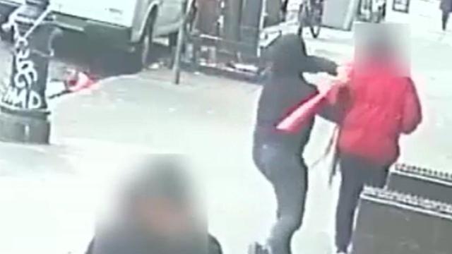 Surveillance video shows a man hitting another man in the back of the head with a baseball bat. 