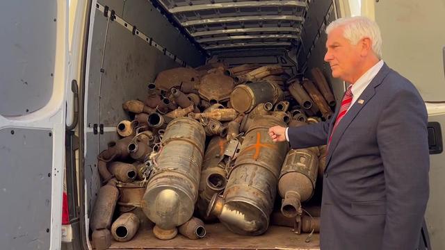 Nassau County Bruce Blakeman stands in front of a truck filled with catalytic converters. 