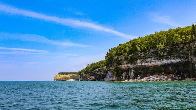 Tall rock wall along a lake. Pictured Rocks National Lakeshore in Michigan ; Location: Pictured Rocks National Lakeshore, Michigan 