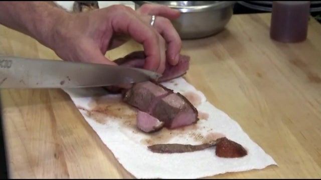 An individual slices foie gras. 