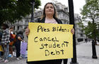 Woman holding a sign reading, "Pres Biden: Cancel student debt" 