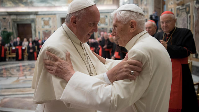 FILE PHOTO: Former pope Benedict is greeted by Pope Francis during a ceremony to mark his 65th anniversary of ordination to the priesthood at the Vatican 
