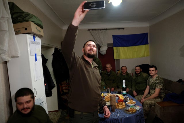 Ukrainian soldier and mortar battery commander Taras Lukinchuk, 30, takes a photo of soldiers as he celebrates New Year's Eve in a military rest house as Russia's attack on Ukraine continues, in Donetsk, Ukraine, December 31, 2022.