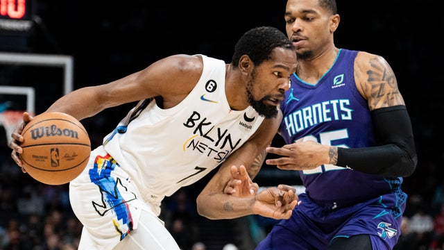 P.J. Washington #25 of the Charlotte Hornets guards Kevin Durant #7 of the Brooklyn Nets in the first quarter during their game at Spectrum Center on December 31, 2022 in Charlotte, North Carolina. 