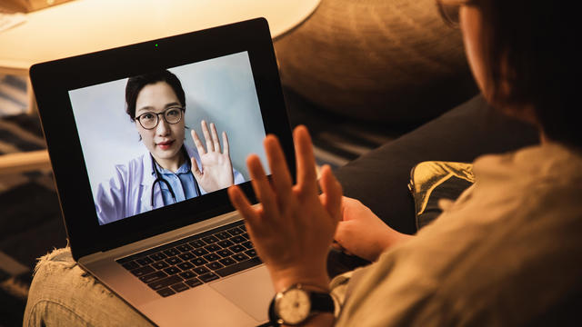 Patient speaks to doctor via video on a laptop 