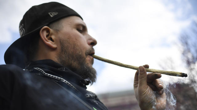 Joshua Frazer smokes a marijuana cigarette outside the Legislative Office Building during a rally April 20, 2021, in Hartford, Conn. 
