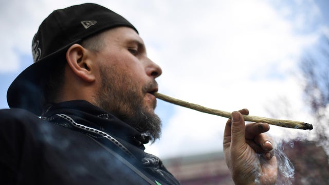 Joshua Frazer smokes a marijuana cigarette outside the Legislative Office Building during a rally April 20, 2021, in Hartford, Conn.