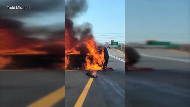 A car on the Long Island Expressway is engulfed in flames. 