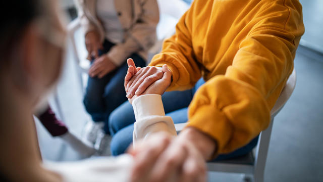 Unrecognizable depressed woman on group therapy, counselling concept. 