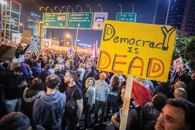 A protester holds a placard expressing his opinion during 
