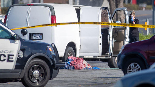 Police investigate a man slumped over the wheel of a van allegely connected to Saturdays mass shooting in Monterey Park 