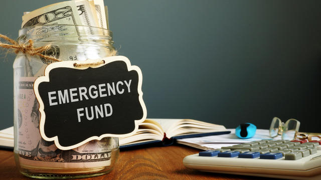 Emergency fund savings written on the jar with money. 