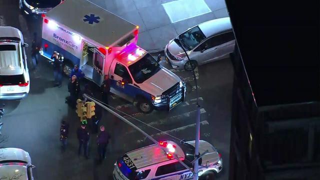 An aerial shot of an ambulance parked on a New York City street near an NYPD vehicle. 