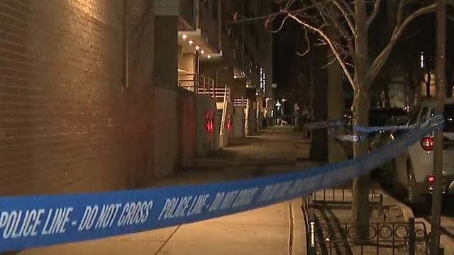 Crime scene tape blocks off a sidewalk outside a Brooklyn apartment building. 