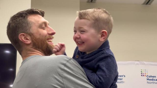 Michael Long holds his 2-year-old son, William Long. 