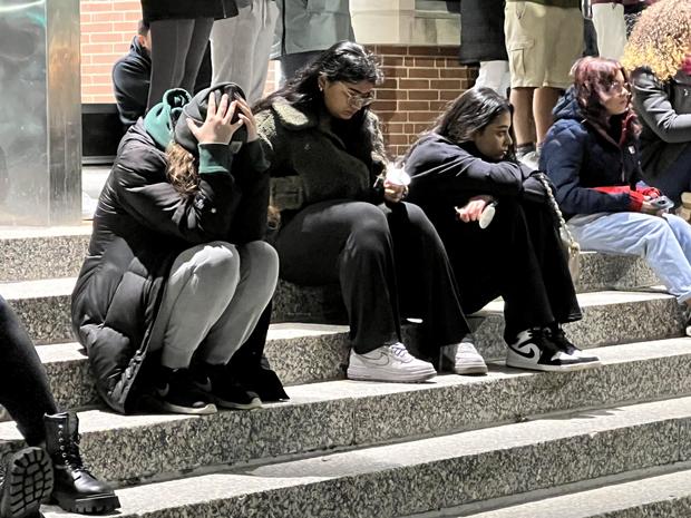 MSU students sitting down with her head cradled in her hands during vigil for students killed in mass shooting 