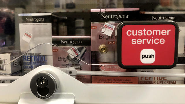 Anti-theft locked merchandise on shelves with customer service button at CVS pharmacy, Queens, New York 