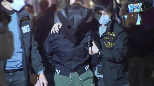 Police officers escort a suspect in connection with the killing of model Abby Choi, in Hong Kong 