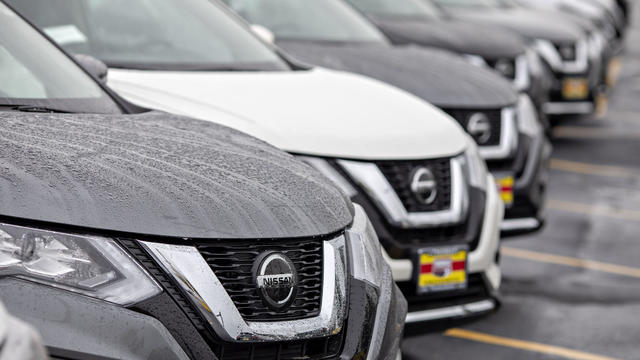 Gray and white hoods of Nissan Rogue SUVs covered with dew 
