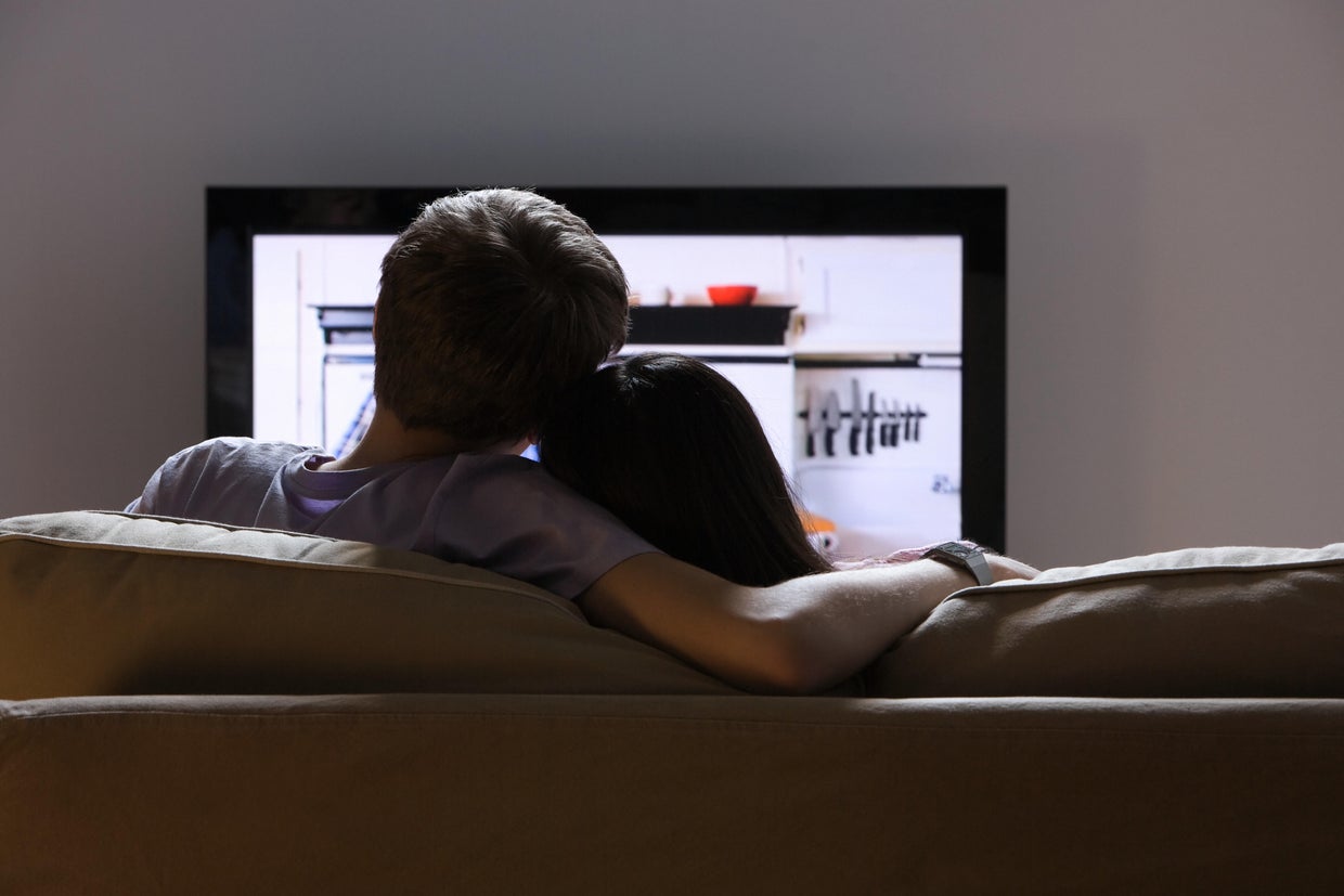 Rear view of a couple watching tv 