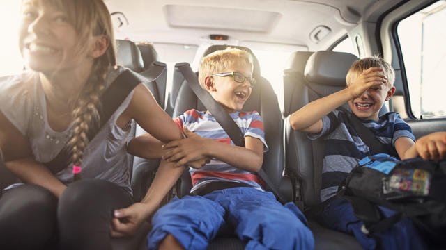 Happy playful kids travelling by car 