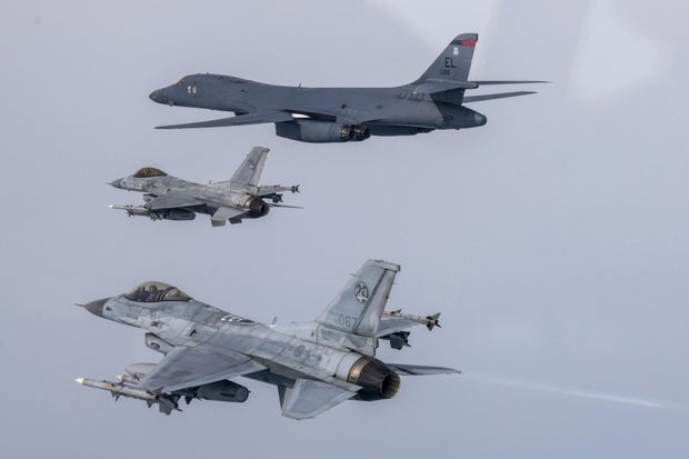 In a photo provided by the South Korean Defense Ministry, a U.S. Air Force B-1B bomber, top, flies in formation with South Korean Air Force KF-16 fighters over the South Korea Peninsula during a joint air drill, March 3, 2023