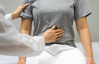 Cropped Hands Of Doctor Examining Woman Abdomen 