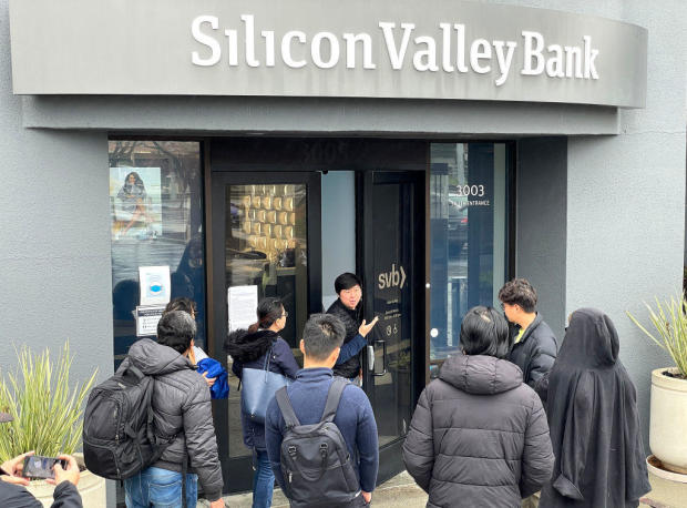 A worker tells people that the Silicon Valley Bank (SVB) headquarters is closed on March 10, 2023 in Santa Clara, California. 