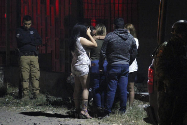 Relatives of some of the victims of a shooting at a nightclub comfort each other outside the premises, in the Apaseo el Grande municipality, Guanajuato state, Mexico, on March 12, 2023. 