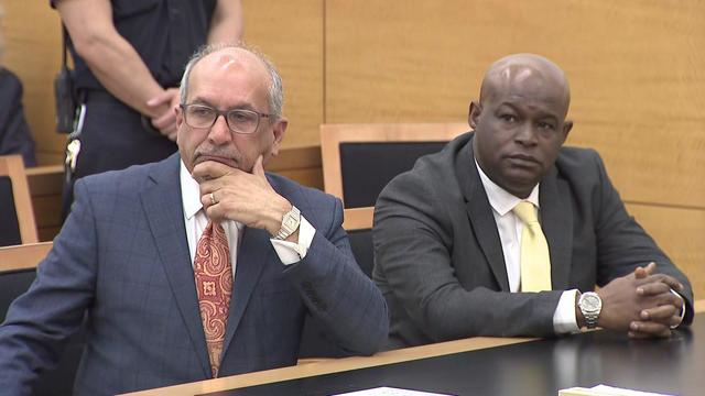 Emel McDowell (right) and his attorney (left) seated in a courtroom. 