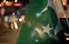 Pakistan day independence or national day celebrations on the city streets, where crowd is motivated to join the parade and cheering with Pakistan flags. 