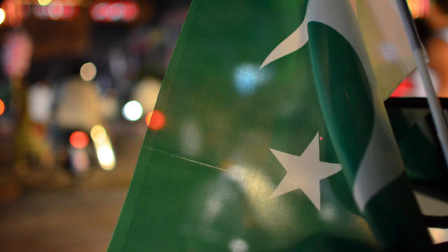 Pakistan day independence or national day celebrations on the city streets, where crowd is motivated to join the parade and cheering with Pakistan flags. 
