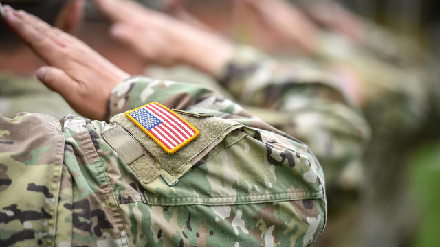 Detail shot with american flag on soldier uniform, giving the honor salute during military ceremony 