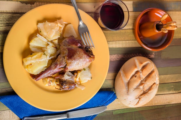 Oven-roasted lamb with potatoes on a yellow plate 