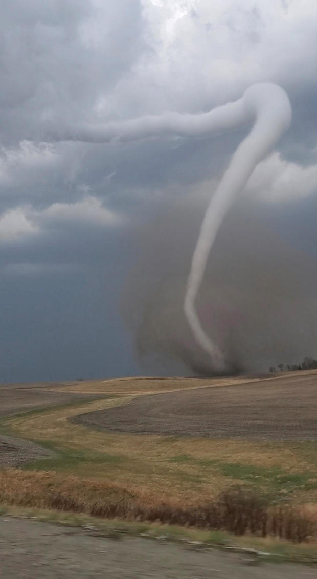 A general view shows a tornado visible in a field near Pleasantville, Iowa, April 4, 2023, in this screenshot obtained from a social media video. 