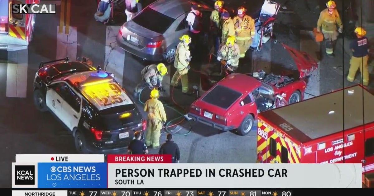 Firefighters try to rescue person trapped in crashed car - CBS Los Angeles