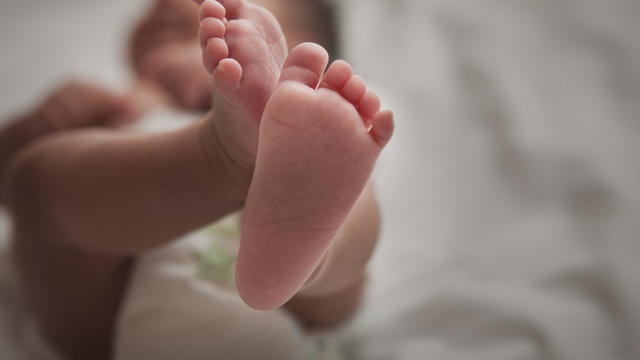 Close up of mixed race newborn baby girl's feet 