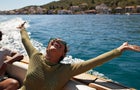 Happy woman with arms raised in motorboat 