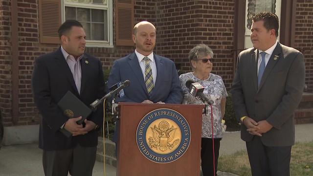 Representatives Nick LaLota, Andrew Garbarino and Anthony D'Esposito stand with a woman outside her Long Island home. 