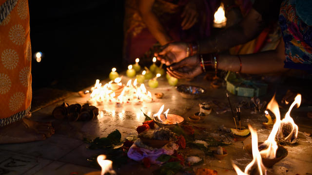 Close-Up Of Hand Holding Illuminated Candles Hindu Religious Activity for Dev Diwali Festival in Varanasi 