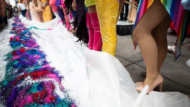 Drag queens stand next to a feather Boa, piled on the ground, during an attempt for a Guinness World Records Title for Longest Feather Boa at 1.2 Miles in celebration of World Pride at Time Square on June 20, 2019 in New York City. 