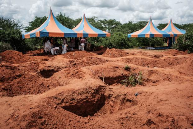 Workers take shelter while digging to exhume bodies from the mass-grave site in Shakahola, Kenya, outside the coastal town of Malindi, April 25, 2023. 