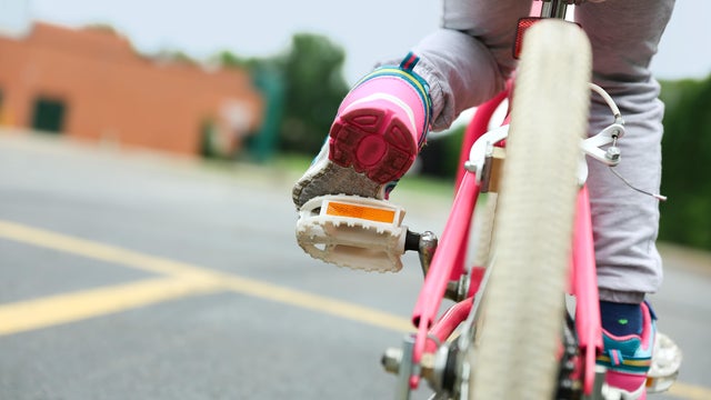 Nice little girl  riding her bike on a road 