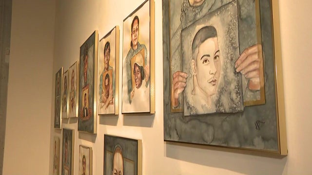 Paintings hang on a wall. 