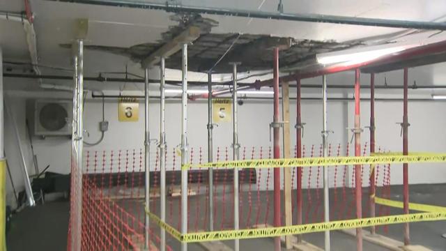 Caution tape surrounds a number of metal and wooden reinforcement beams up against the ceiling. 